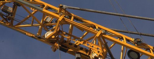 Part of a yellow crane against a blue sky